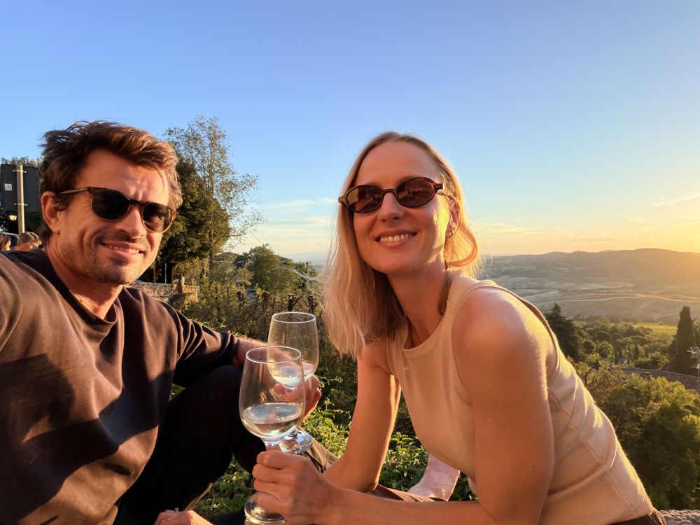 Paul and Mia toasting with white wine at golden hour